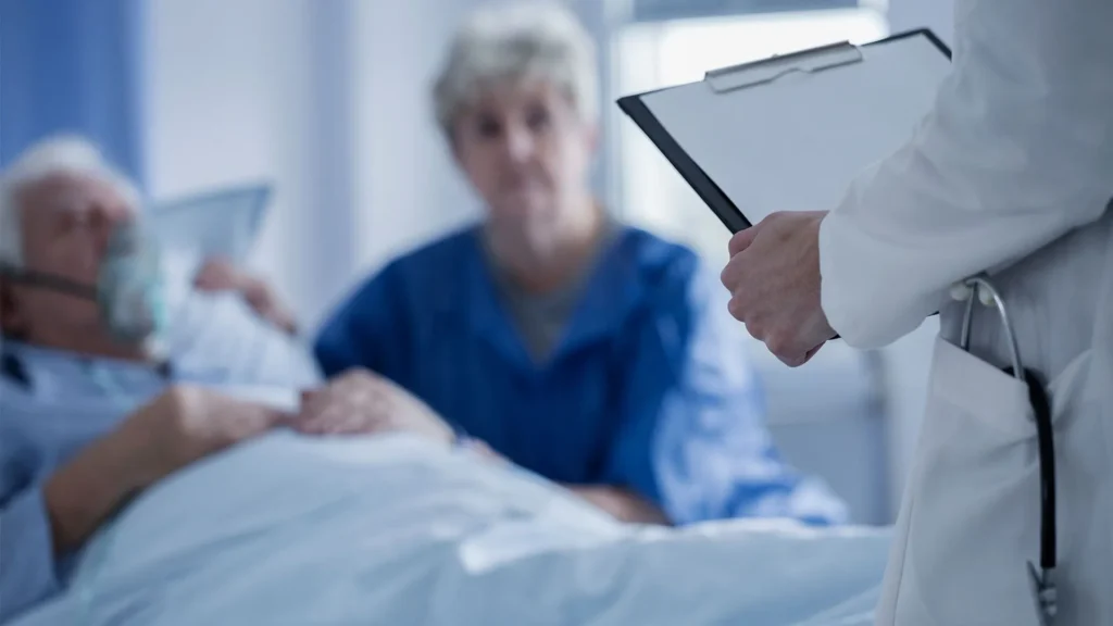 a doctor standing in front of an elderly patient