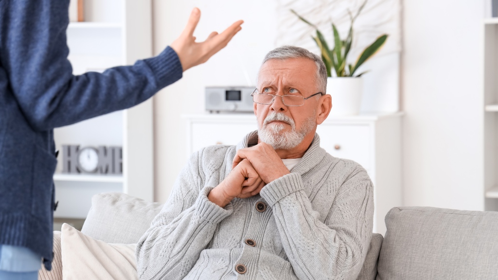 Female caregiver mistreating senior man in nursing home