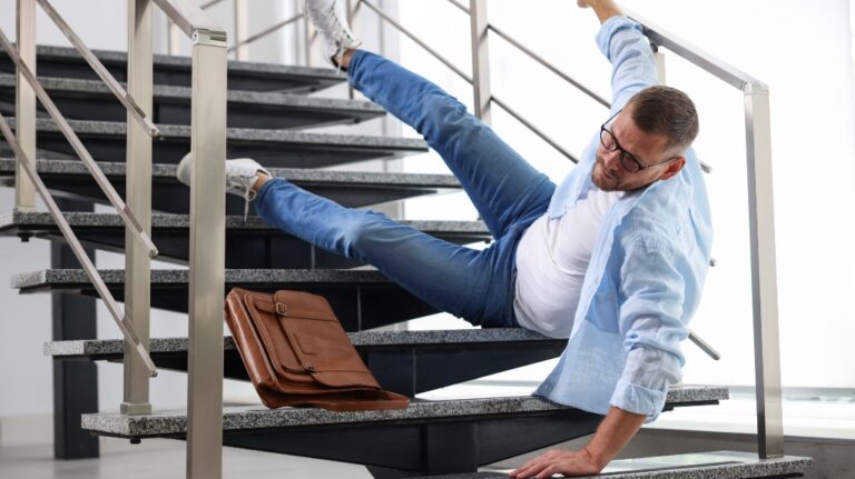 man slips and falls down stairs