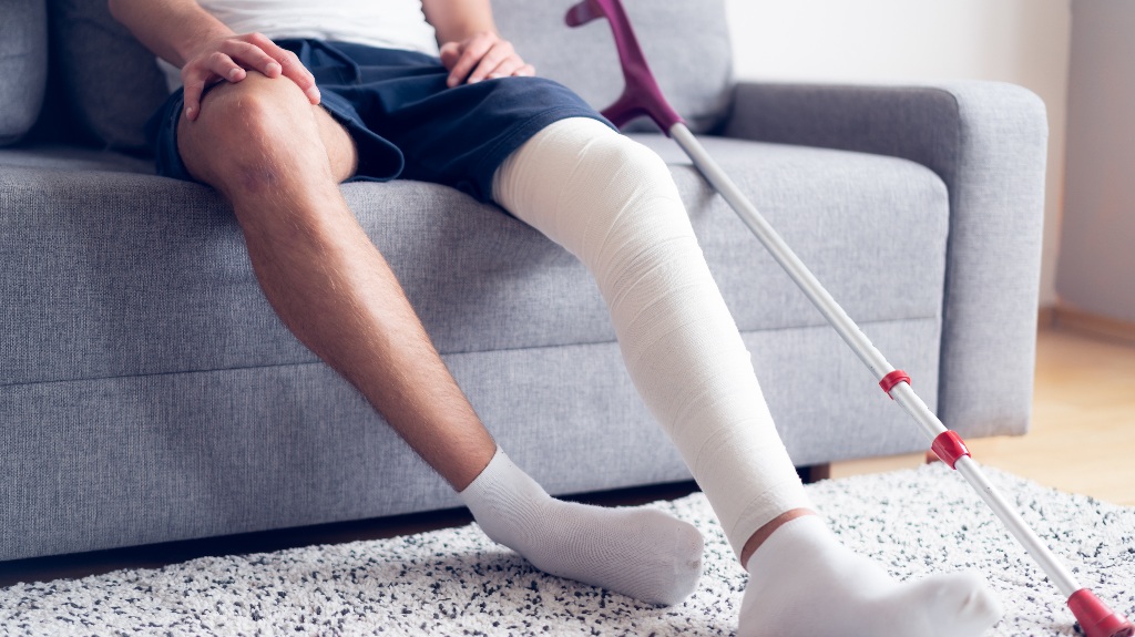Young man with injured knee recovering at home