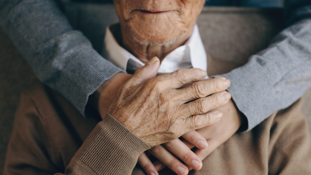 son is hugging his senior father