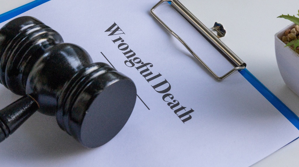 wrongful death document in a clipboard with a judge's gavel on a desk