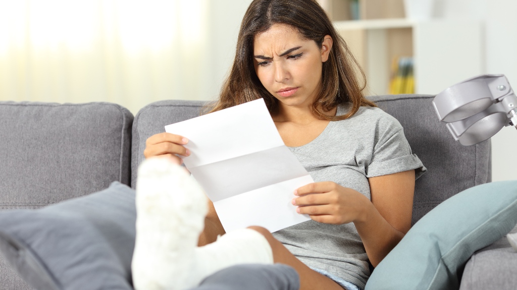 sad woman with leg injury is reading letter
