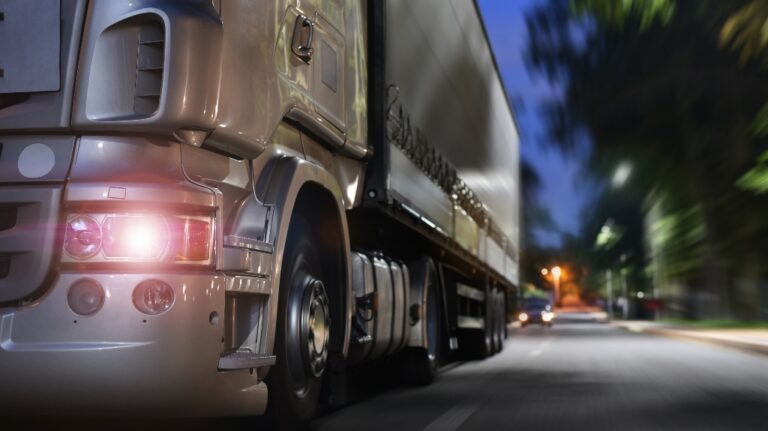 Semi-truck drives through the city at night