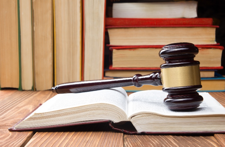 Open law book with a wooden judges gavel