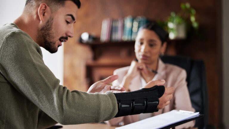 Man with injured hand is consulting with lawyer