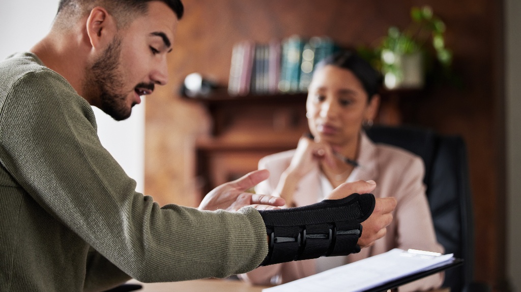 Man with injured hand is consulting with lawyer
